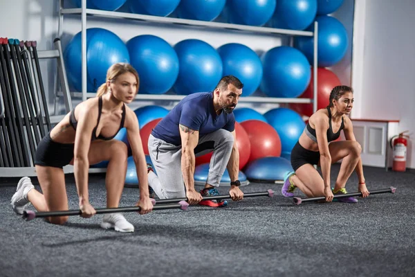 Fitness Eğitmeni ve fitbar ile egzersiz yapıyor kızlar