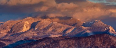 Yüksek dağlarda kar günbatımı ışık ile toz