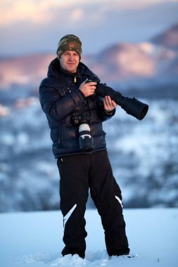 Photographer with two cameras shooting landscapes at sunset clipart