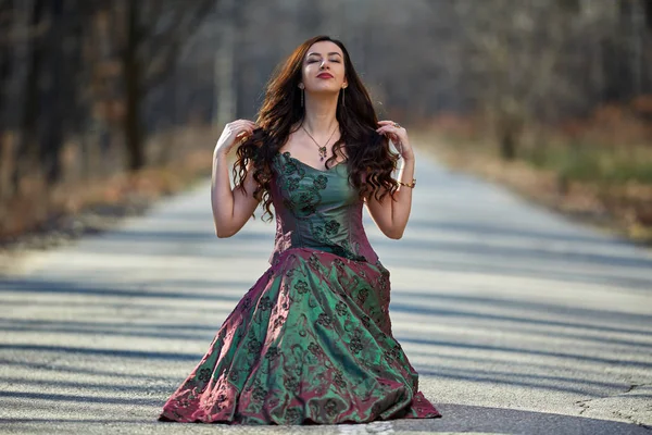 Mujer vestida sentada en el camino — Foto de Stock