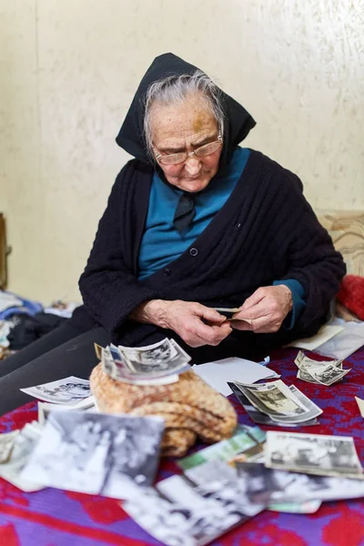 Old woman looking at photos — Stock Photo, Image