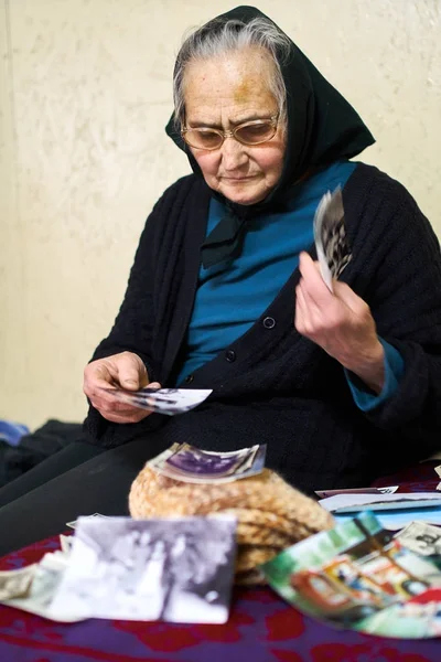 Old woman looking at photos — Stock Photo, Image