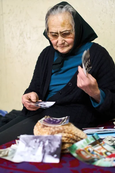 Alte Frau schaut sich Fotos an — Stockfoto