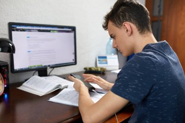 Özenle ödev ile bilgisayar masasında öğrenci