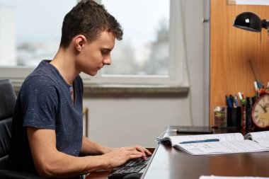 Öğrenci ödevi ile bilgisayar masasında