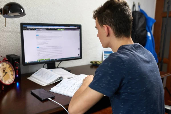 Öğrenci ödevi ile bilgisayar masasında