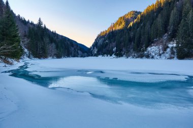 Çam ormanı içinde kaplı dağları arasında donmuş gölün peyzaj