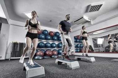 Fitness Eğitmeni ve Stepper ile kardiyo egzersiz yapıyor kadın
