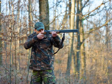 Çift namlulu av tüfeği ile kamuflaj takım elbise avcı