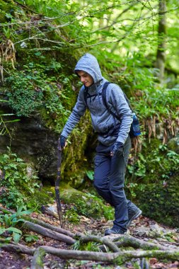 Orman yoluyla izinde hiking sırt çantası ile genç çocuk