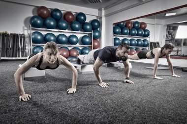 Şınav spor salonunda fitness eğitmeni ve genç kadınlar