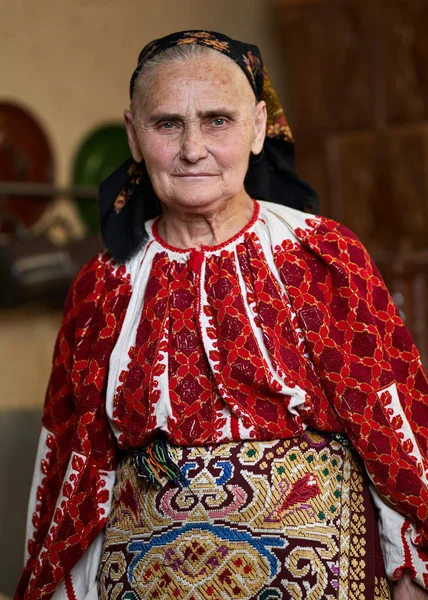 老罗马尼亚妇女身着传统服装看相机的特写视图 — 图库照片