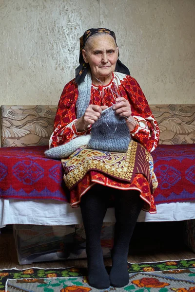 Παλιά Ρουμανική Γυναίκα Παραδοσιακή Φορεσιά Κάθεται Στον Καναπέ Και Πλέξιμο — Φωτογραφία Αρχείου