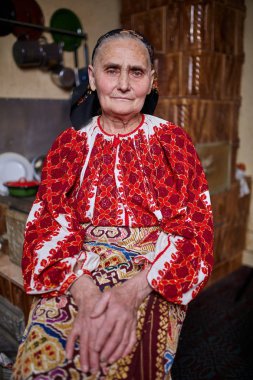 Ocakta oturan geleneksel Kostüm giymiş eski Rumen kadın
