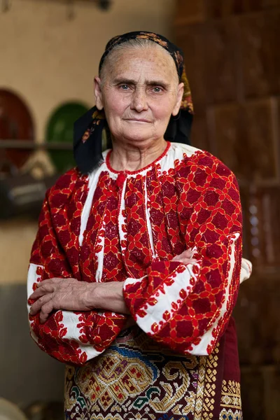 老罗马尼亚妇女身着传统服装折叠武器和看相机 — 图库照片