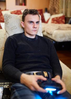 Koltukta oturuyor ve video oyunları oynarken genç çocuk