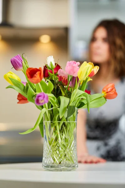 背景上模糊的女人的五颜六色的郁金香花束 — 图库照片