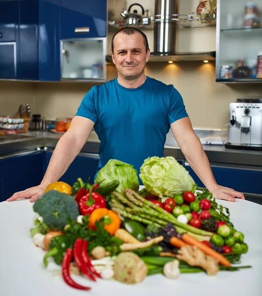Az ember a konyhában zöldségekkel — Stock Fotó