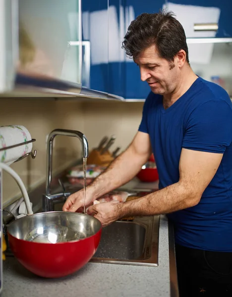 Man washing chicken drumsticks — Stock Photo, Image