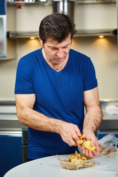 Homme épluchant des pommes de terre — Photo