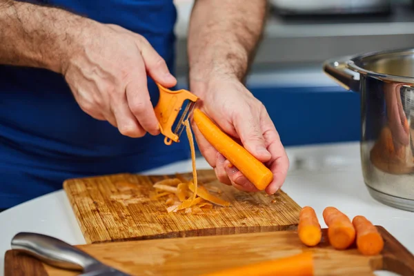 Homem descascando cenouras — Fotografia de Stock