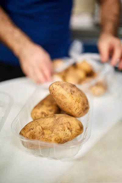 Человек чистит картошку — стоковое фото