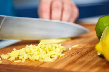 Adam bir tarifi için ahşap bir gemide taze zencefil doğrama