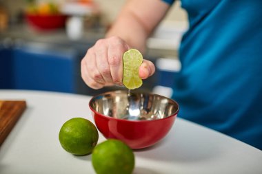 Seçici odak bir kasenin içine yarım limon sıkarak adam
