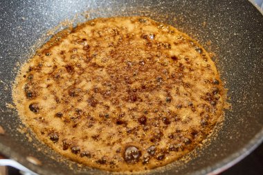 Kahverengi şeker bir wok tavada caramelizing