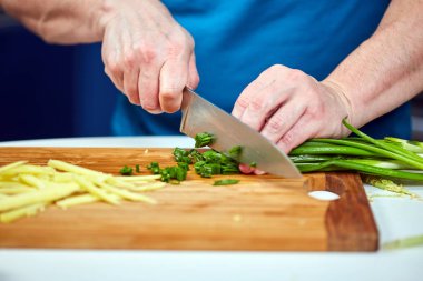 Taze soğan Doğrama ahşap kurulu üzerinde closeup çekim adam