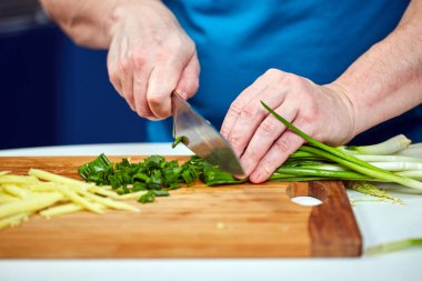 Taze soğan Doğrama ahşap kurulu üzerinde closeup çekim adam