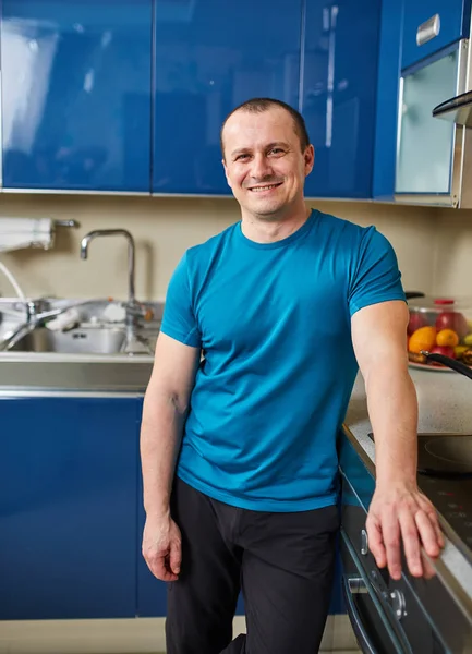 Uomo Felice Piedi Nella Sua Cucina Appoggiato Sul Fornello — Foto Stock