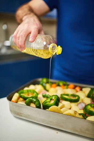 Homem Adicionando Óleo Uma Bandeja Com Baquetas Legumes — Fotografia de Stock