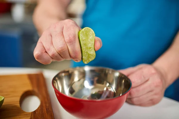 Man Knijpen Van Halve Limoen Een Kom Selectieve Aandacht — Stockfoto