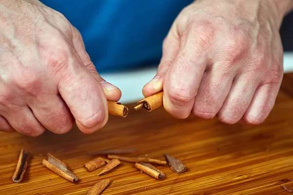 Hombre Rompiendo Palo Canela Sobre Una Tabla Madera — Foto de Stock