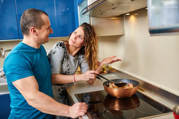 Couple cooking at home, wife not impressed with husband\'s cooking results