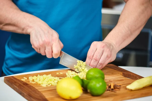 レシピ板で新鮮な生姜を刻んで男 — ストック写真