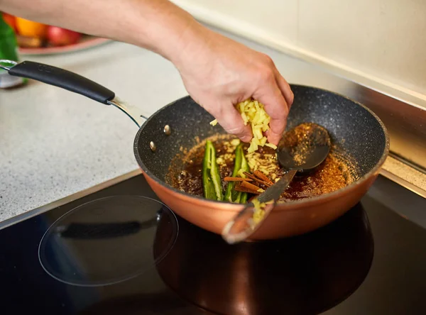 中華鍋でカラメル状の砂糖の材料を入れる男 — ストック写真