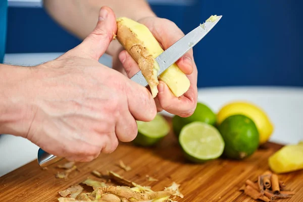 Uomo Peeling Zenzero Una Tavola Legno — Foto Stock