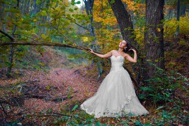 Ormanda gelinliğiyle güzel bir gelinin samimi portresi.