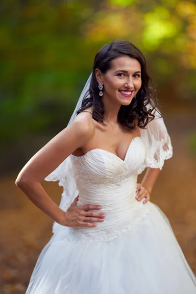 Candid portrait of a beautiful bride in her wedding dress in the forest