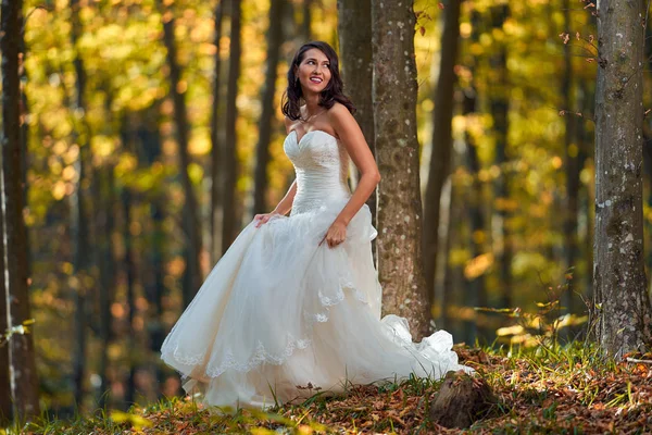 Candid portrait of a beautiful bride in her wedding dress in the forest