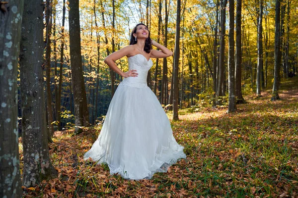 Candid portrait of a beautiful bride in her wedding dress in the forest