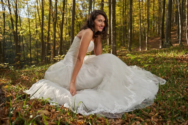 Candid portrait of a beautiful bride in her wedding dress in the forest
