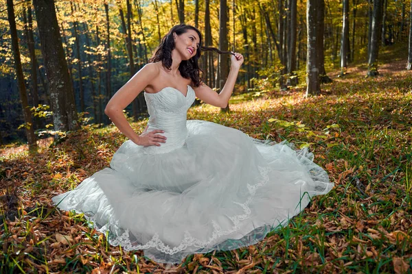 Candid portrait of a beautiful bride in her wedding dress in the forest