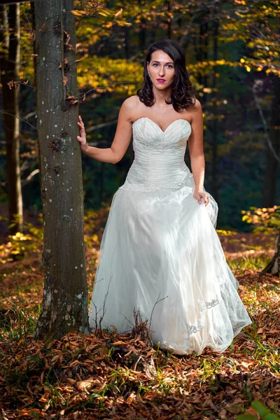 Candid portrait of a beautiful bride in her wedding dress in the forest