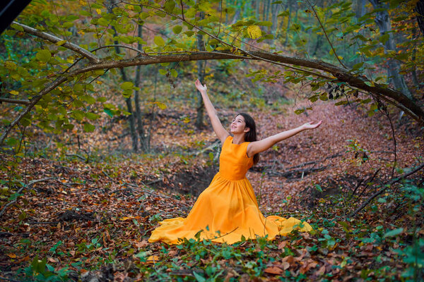 Teenage girl in yellow dress in the forest