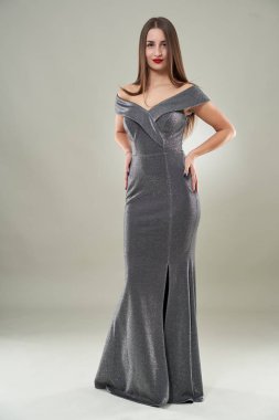 Uzun, parlak elbiseli güzel bir kadının uzun bir portresi, stüdyo fotoğrafı.