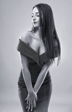 Gri arka planda güzel bir genç kadının siyah beyaz portresi