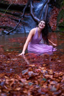 Şelalenin yanındaki gölde güzel, genç bir İspanyol kadın.